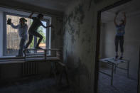 Women work to reconstruct a damaged fire department from Russian strikes, in Makariv, Kyiv region, Ukraine, Wednesday, June 29, 2022. Many buildings in Makariv were destroyed or partially damaged in the first weeks of the war. The youth volunteer movement 'Building Ukraine Together,' has since 2014 helped restore damaged buildings in eastern Ukraine. (AP Photo/Nariman El-Mofty)