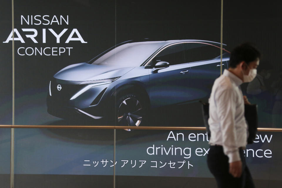 A man walks past the global headquarters of Nissan Motor Co., Ltd. in Yokohama near Tokyo, Wednesday, May 27, 2020. The Japanese-French auto alliance of Nissan and Renault will be sharing more vehicle parts, technology and models to save costs as the industry struggles to survive the coronavirus pandemic. (AP Photo/Koji Sasahara)