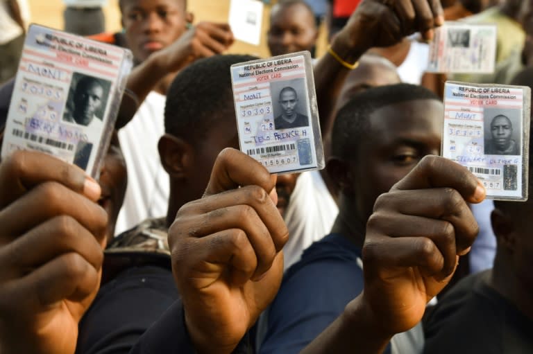 Voters hold their voting card prior to casting their vote for Liberia's presidential and legislatives elections, at a polling station in Monrovia on October 10, 2017