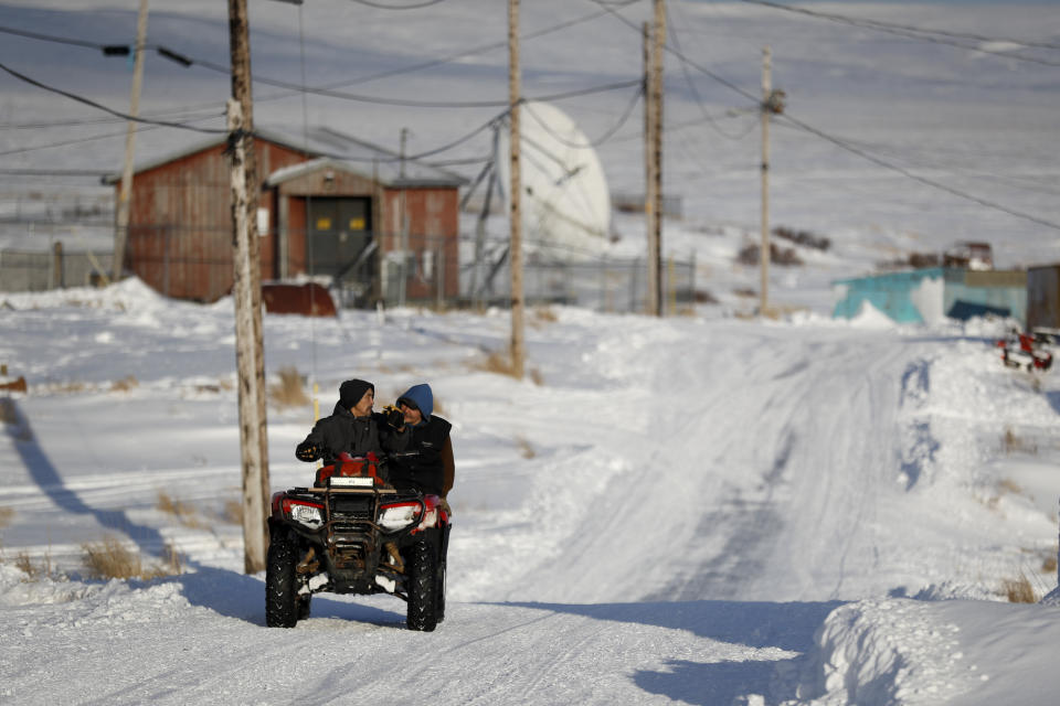 People ride through town on all-terrain vehicles Saturday, Jan. 18, 2020, in Toksook Bay, Alaska. The first Americans to be counted in the 2020 Census starting Tuesday, Jan. 21, live in this Bering Sea coastal village. The Census traditionally begins earlier in Alaska than the rest of the nation because frozen ground allows easier access for Census workers, and rural Alaska will scatter with the spring thaw to traditional hunting and fishing grounds. (AP Photo/Gregory Bull)