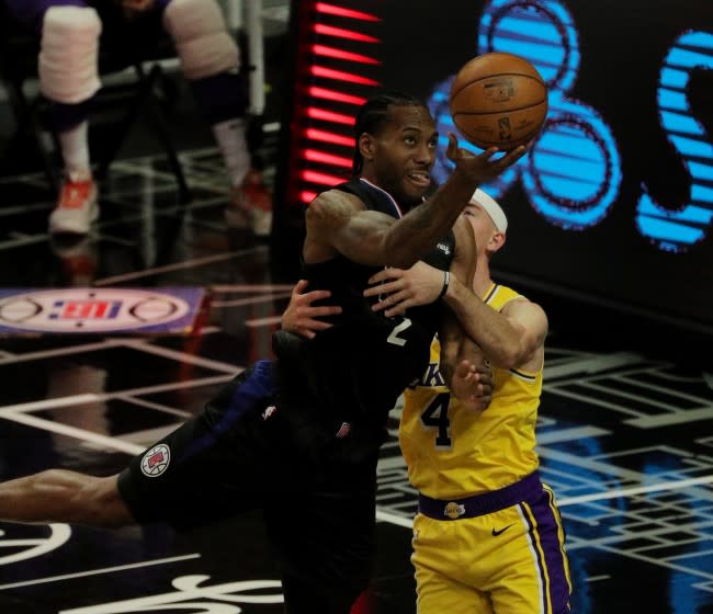 LOS ANGELES, CA - MAY 6, 2021: LA Clippers forward Kawhi Leonard (2) is fouled by Los Angeles Lakers guard Alex Caruso (4) as he drives to the basket in the second half at Staples Center on May 6, 2021 in Los Angeles, California.(Gina Ferazzi / Los Angeles Times)