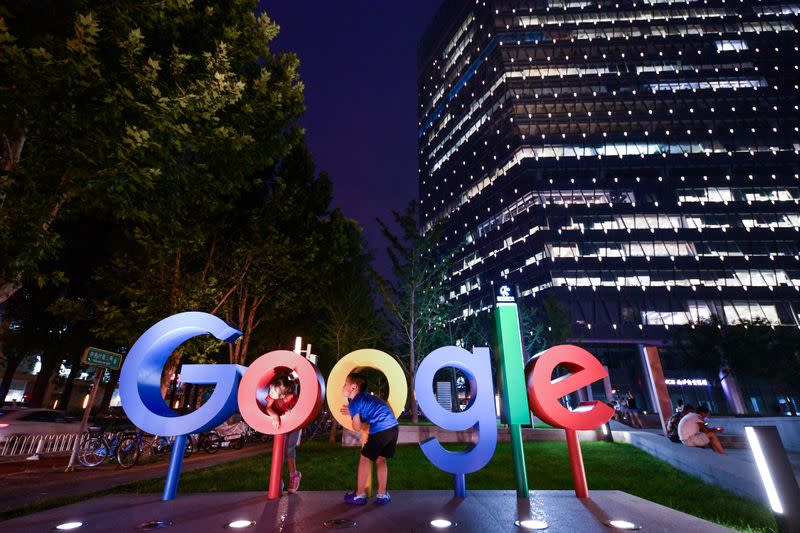 Children play around a sign of Alphabet Inc&#39;s Google outside its office in Beijing