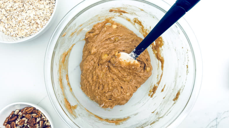 wet cookie dough in glass bowl with rubber spatula