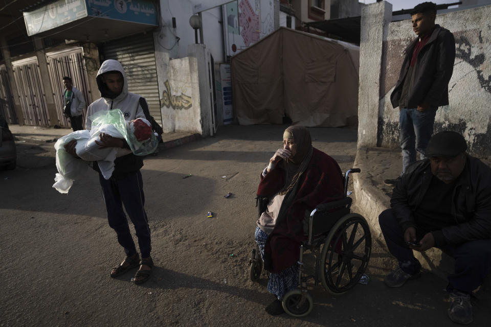 A relative of Masa Shouman holds her body during her funeral in Rafah, southern Gaza, Wednesday, Jan. 17, 2024. Shouman was killed in an Israeli bombardment of the Gaza Strip. (AP Photo/Fatima Shbair)