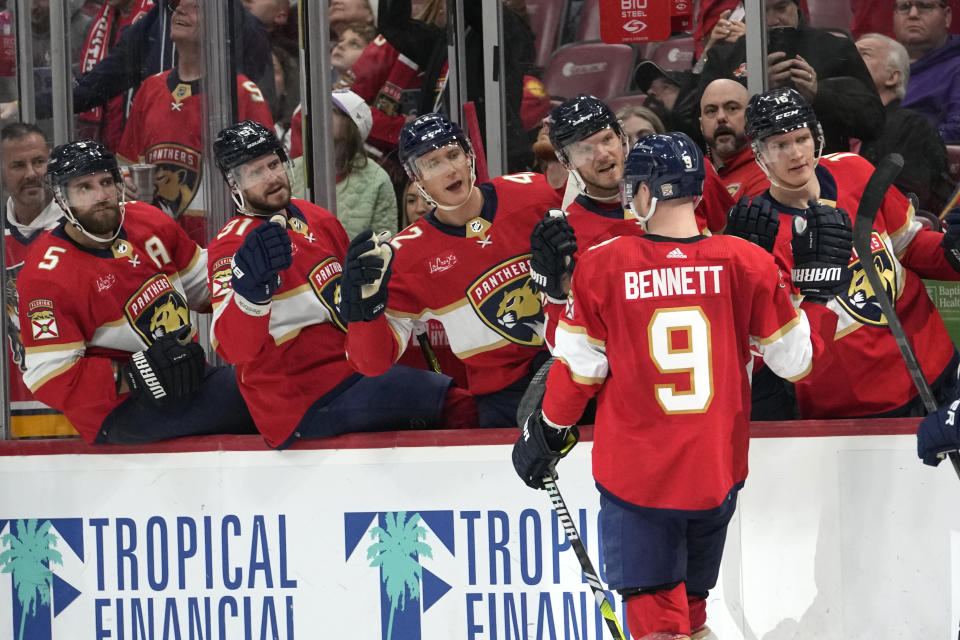 Florida Panthers center Sam Bennett (9) is congratulated by teammates after scoring a goal during the second period of an NHL hockey game against the Vegas Golden Knights, Saturday, Dec. 23, 2023, in Sunrise, Fla. (AP Photo/Lynne Sladky)