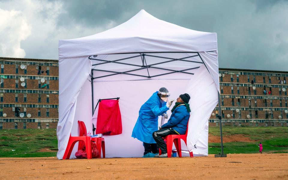 A resident from the Alexandra township gets tested for COVID-19 in Johannesburg, South Africa. A dangerous stigma has sprung up around the coronavirus in Africa fueled, in part, by severe quarantine rules in some countries as well as insufficient information about the virus.  - Jerome Delay/AP