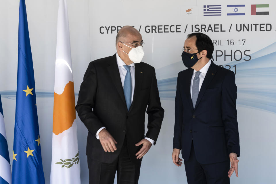 Cyprus' foreign minister Nicos Christodoulides, right, talks with his Greek counterpart Nikos Dendias before a meeting of the ministers of foreign affairs of Cyprus, Greece, Israel and United Arab of Emirates in city of Paphos, Cyprus, Friday, April 16, 2021. The event marks the first time the foreign ministers of all four countries have met following the recent normalization of relations between Israel and the United Arab Emirates and aims to expand cooperation to bolster regional stability. (Iakovos Hatzistavrou/Pool via AP)