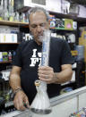 Jay Work performs a demonstration using tobacco in a water pipe at his Grateful J's smoke shop, Thursday, Jan. 12, 2017, in Margate, Fla. High-end German glass water pipe maker Roor and its American licensee are filing lawsuits against smoke shops and mom-and-pop convenience stores in Florida, California and New York alleging that they are selling Roor counterfeits, violating its trademark. (AP Photo/Alan Diaz)