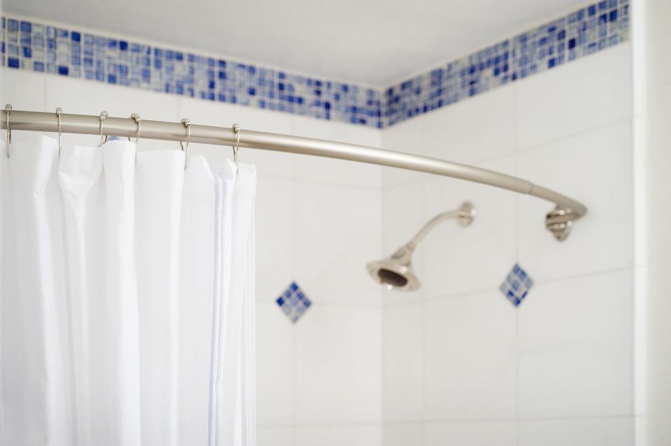 detail shower curtain and shower head in blue and white tiled shower