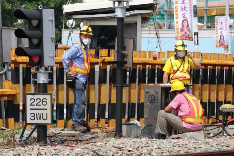 彰化縣大村鄉中正西路平交道故障，柵欄桿子一直呈放下狀態，警示燈號與聲響不斷，台鐵人員10日持續在鐵軌旁搶修設備。（中央社）