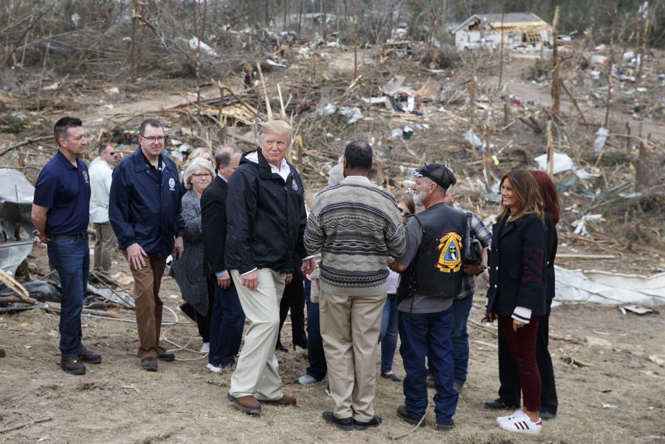 President Donald Trump and first lady Melania Trump, right, talk with people Beauregard, Ala., Friday, March 8, 2019, as they travel to tour areas where tornados killed 23 people in Lee County, Ala. (AP Photo/Carolyn Kaster)