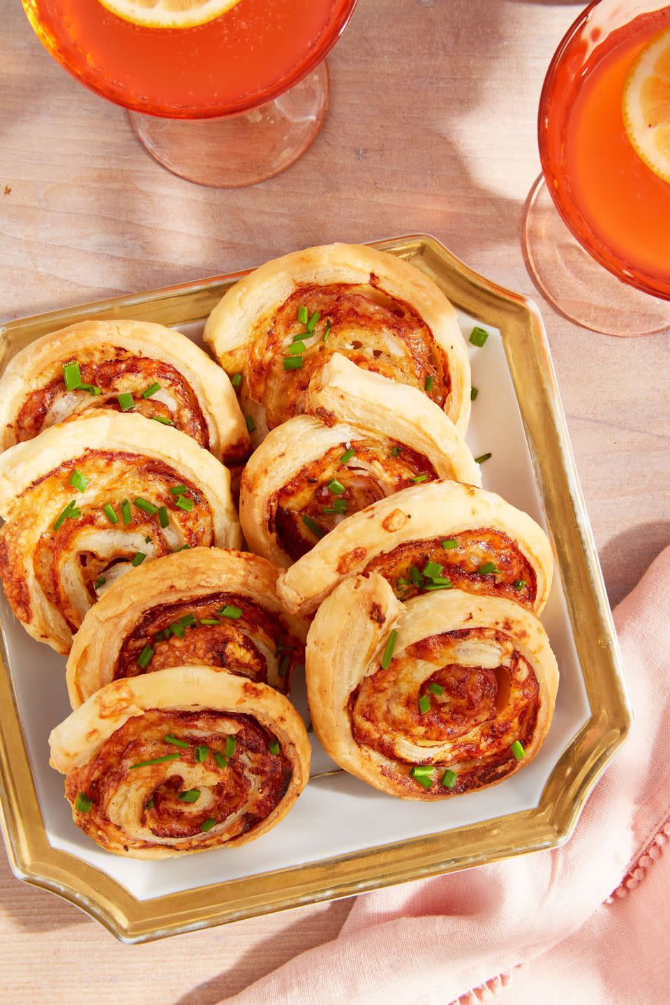 ham and cheese pinwheels arranged on a serving plate with gold trim