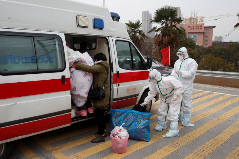 Hospital staff in protective garments pick up a leukaemia patient who arrived from the Hubei province exclusion zone at a checkpoint at the Jiujiang Yangtze River Bridge in Jiujiang