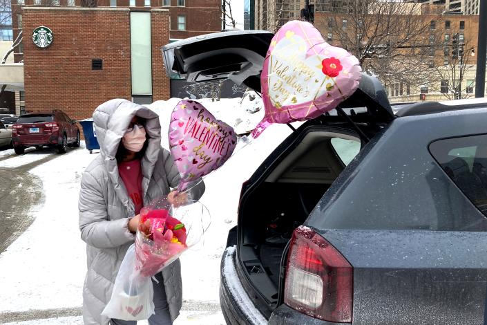 Ellen Yun loads Valentine&#39;s Day gifts for her mom, sister and brother in-laws, nephew and her two children Saturday, Feb. 13, 2021, outside a Chicago area grocery store. Yun said she had shopped for her husband earlier.