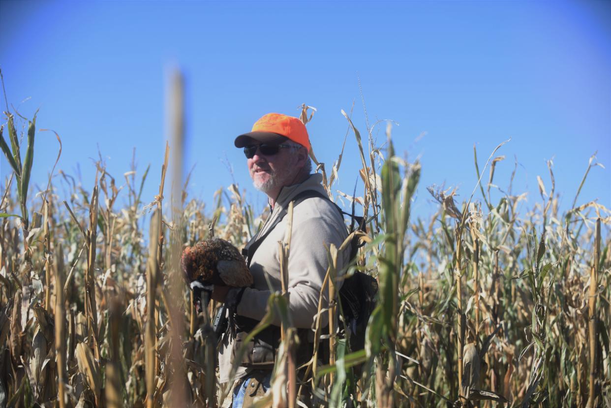 Q McEntee carries pheasant he helped guide a group of about twenty hunters to on opening day of the hunting season, October 16, 2021, in western South Dakota.