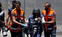 <p>A wounded photojournalist is evacuated during a protest by Palestinians marking the 70th anniversary of Nakba, in Bethlehem in the occupied West Bank, May 15, 2018. (Photo Mussa Qawasma/Reuters) </p>