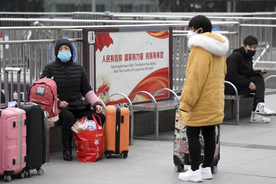 Travelers sit with their luggage outside the closed Hankou Railway Station in Wuhan in central China's Hubei Province, Thursday, Jan. 23, 2020. Overnight, Wuhan authorities announced that the airport and train stations would be closed, and all public transportation suspended by 10 a.m. Friday. Unless they had a special reason, the government said, residents should not leave Wuhan, the sprawling central Chinese city of 11 million that's the epicenter of an epidemic that has infected nearly 600 people. (Chinatopix via AP)