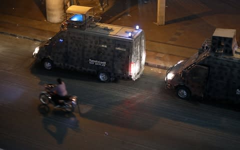 Police vehicles are seen in central Cairo as protesters gather shouting anti-government slogans in Cairo - Credit: Reuters