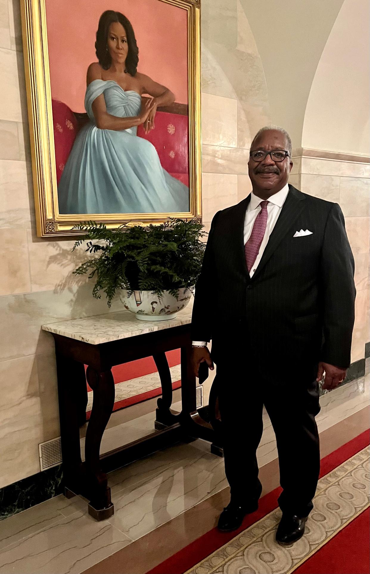 West Palm Beach Mayor Keith James stands next to a portrait of former First Lady Michelle Obama during his trip to the White House.