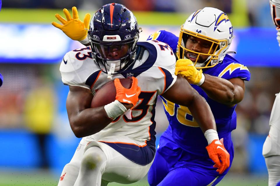Denver Broncos running back Javonte Williams (33) runs the ball against Los Angeles Chargers linebacker Justin Hollins (58) during the second half at SoFi Stadium.