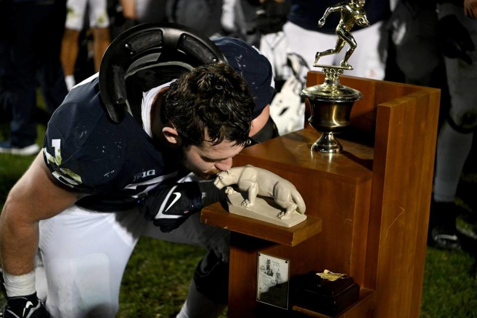 Penn State offensive lineman Bryce Effacer kisses the Land-Grant Trophy after the win over Michigan State on Saturday, Nov. 26, 2022.