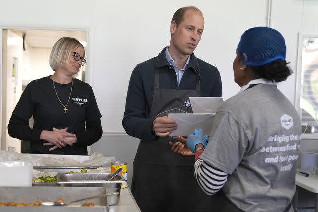 <p>Alastair Grant-WPA Pool/Getty Images</p> Prince William accepts cards from volunteer Rachel Candappa during a visit to Surplus to Supper in Sunbury-on-Thames, Surrey, on April 18, 2024.