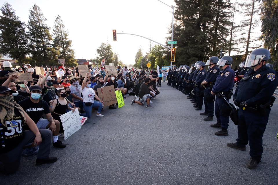 Protesters kneel before California Highway Patrol officers (AP)