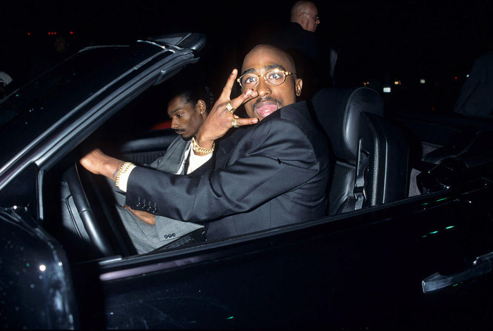 “He knows something’s gonna happen,” says Hughes of Snoop Dogg, photographed here with Shakur. (Credit: Kevin Mazur Archive/WireImage via Getty Images)