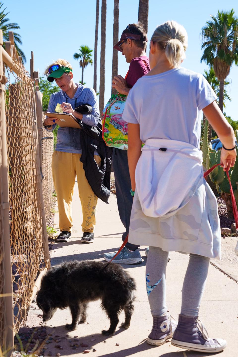 Carissa Sipp (left), Dan Hunt (right) and their daughter, Alessandra Sipp (front) stop at a house while canvassing for the Environmental Voter Project on Oct. 29, 2022, in Tucson. Their goal is to encourage environmentally aware voters to cast their ballots.