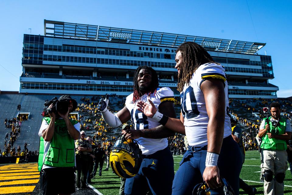 Michigan's Eyabi Okie, left, and Mike Morris celebrate after a NCAA Big Ten Conference college football game against Iowa, Saturday, Oct. 1, 2022, at Kinnick Stadium in Iowa City, Iowa.