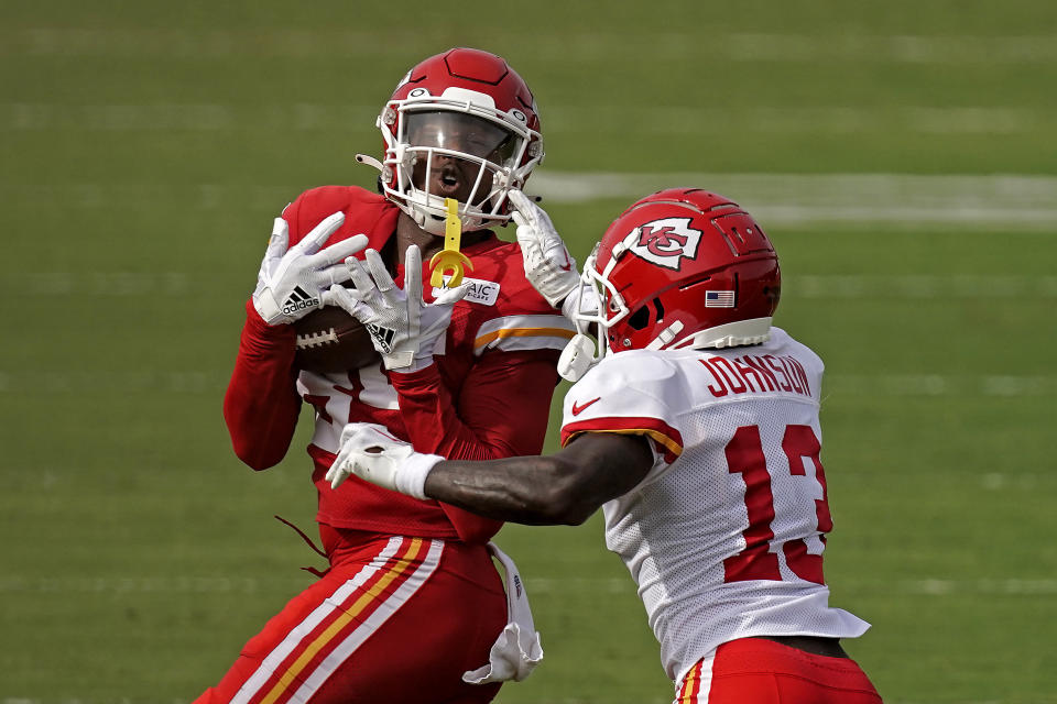 Kansas City Chiefs wide receiver Omar Bayless, left, catches a pass under pressure from safety Nazeeh Johnson (13) during NFL football training camp Sunday, Aug. 7, 2022, in St. Joseph, Mo. (AP Photo/Charlie Riedel)