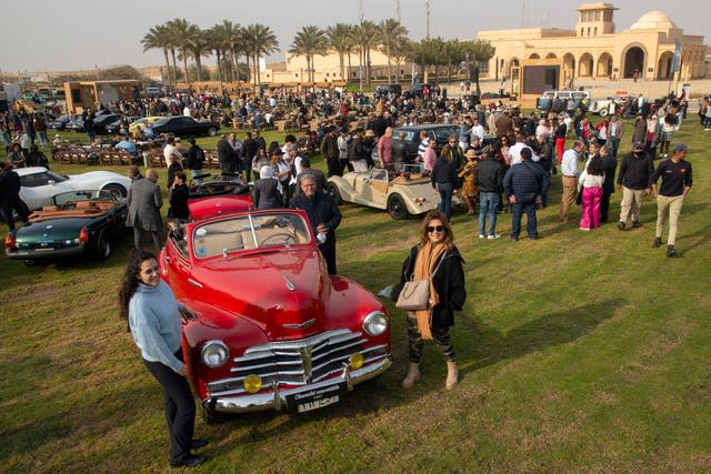 Automobile enthusiasts pose for a picture during a classic car show in Cairo, Egypt