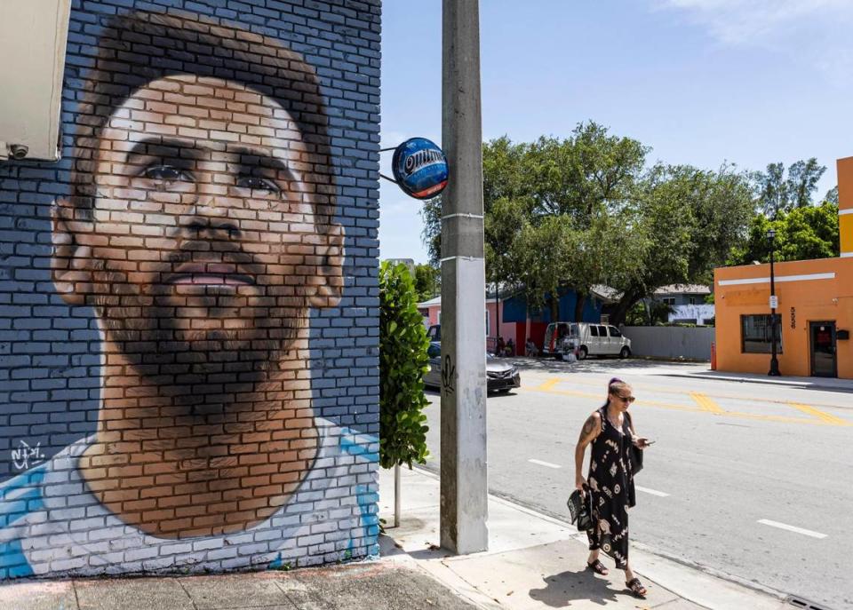 A woman walks past a Lionel Messi mural located at Fiorito Argentinian restaurant.