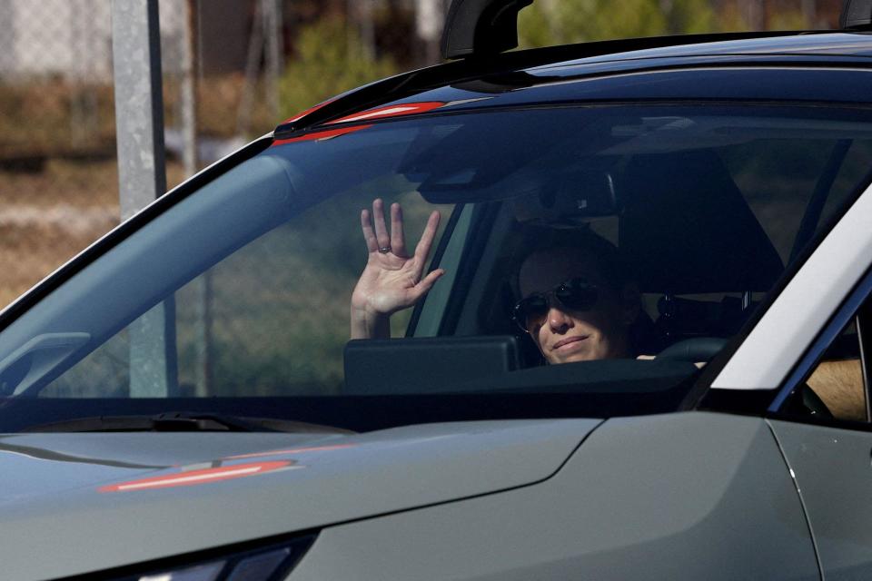 Carolina González, filha de Edmundo González, acena de dentro de um carro no aeroporto militar de Torrejón de Ardoz, Madrid.