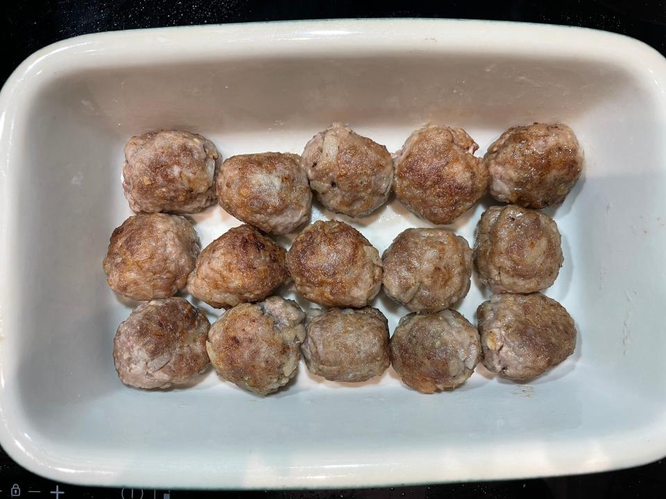 meatballs lining a ceramic baking dish