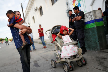 Honduran migrant Alvin Reyes, 39, embraces his son David, 2, next to his daughter Maria, 6, in front of the police station in Pijijiapan, Mexico, November 4, 2018. REUTERS/Carlos Garcia Rawlins