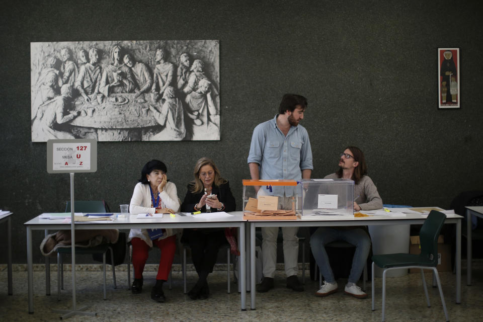 Election officials wait for voters at a polling station for the general election in Madrid, Spain, Sunday, Nov. 10, 2019. Spain holds its second national election this year after Socialist leader Pedro Sanchez failed to win support for his government in a fractured Parliament. (AP Photo/Manu Fernandez)