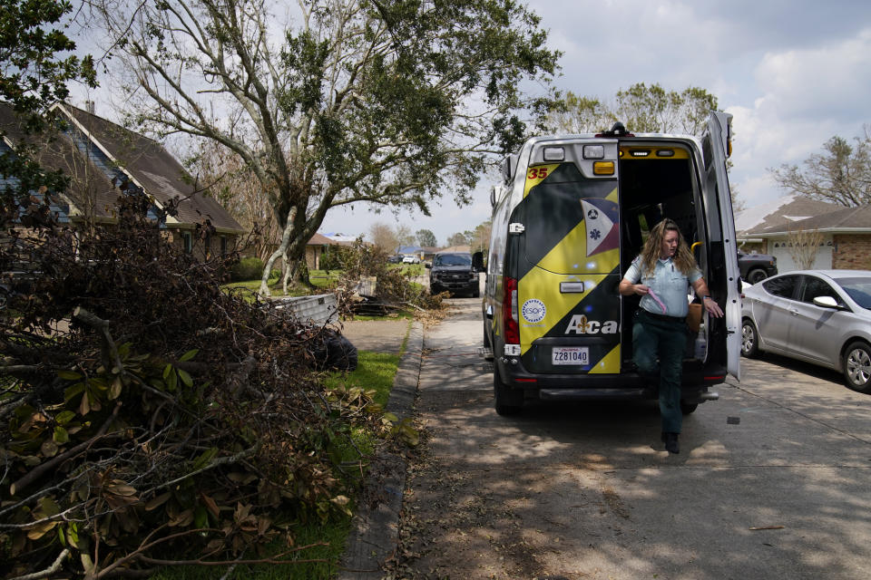 Paramedic Laura Russell of Acadian Ambulance service gets out of an ambulance on a call in a neighborhood damaged by Hurricane Ida, Friday, Sept. 3, 2021, in Houma, La. (AP Photo/John Locher)