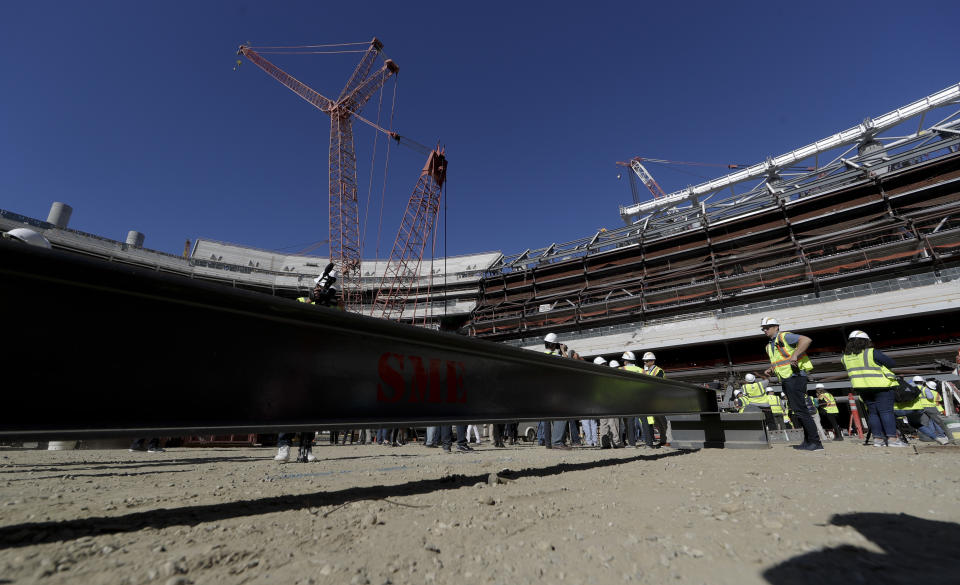 Visitors tour the LA Stadium construction site on Tuesday, Sept. 18, 2018, in Inglewood, Calif. The new facility for the Los Angeles Rams and Los Angeles Chargers is tentatively scheduled to be competed for the 2020 NFL football season. (AP Photo/Chris Carlson)