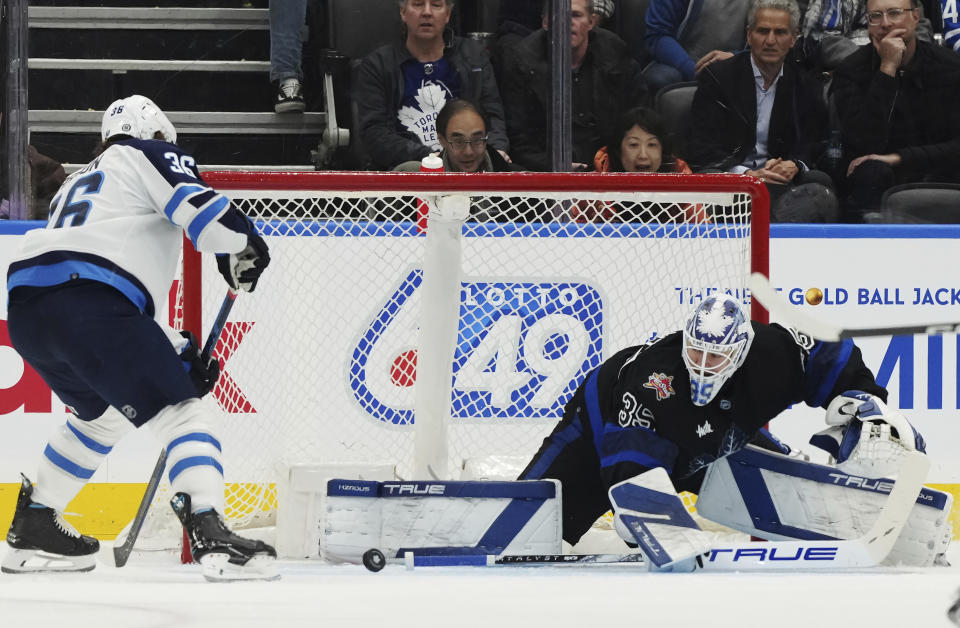 Toronto Maple Leafs goaltender Ilya Samsonov (35) makes a save against Winnipeg Jets forward Morgan Barron (36) during the second period of an NHL hockey game Wednesday, Jan. 24, 2024, in Toronto. (Nathan Denvette/The Canadian Press via AP)