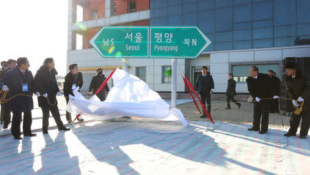 South and North Korean officials unveil the sign of Seoul to Pyeongyang during a groundbreaking ceremony for the reconnection of railways and roads at the Panmun Station in Kaesong, North Korea, December 26, 2018. Yonhap via REUTERS