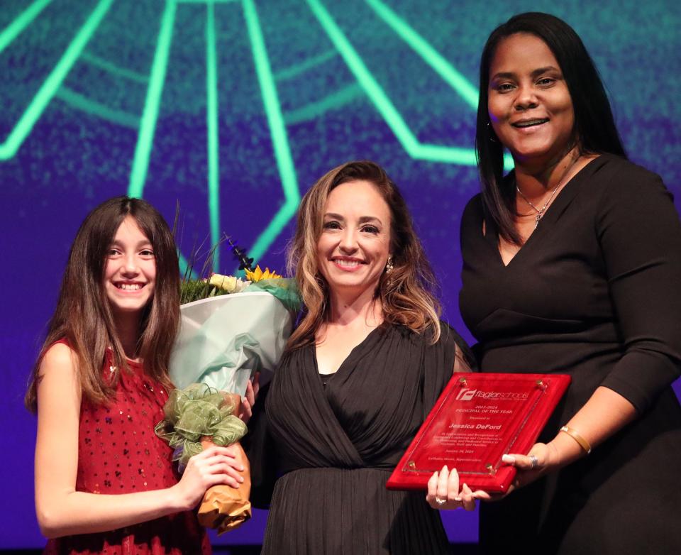 Student Liliana Fanelli presents flowers to 2023-24 Principal of the Year Jessica DeFord, Belle Terre Elementary, with Superintendent LaShakia Moore, Wednesday, Jan. 24, 2024, during A Night of Legends at the Flagler Auditorium.