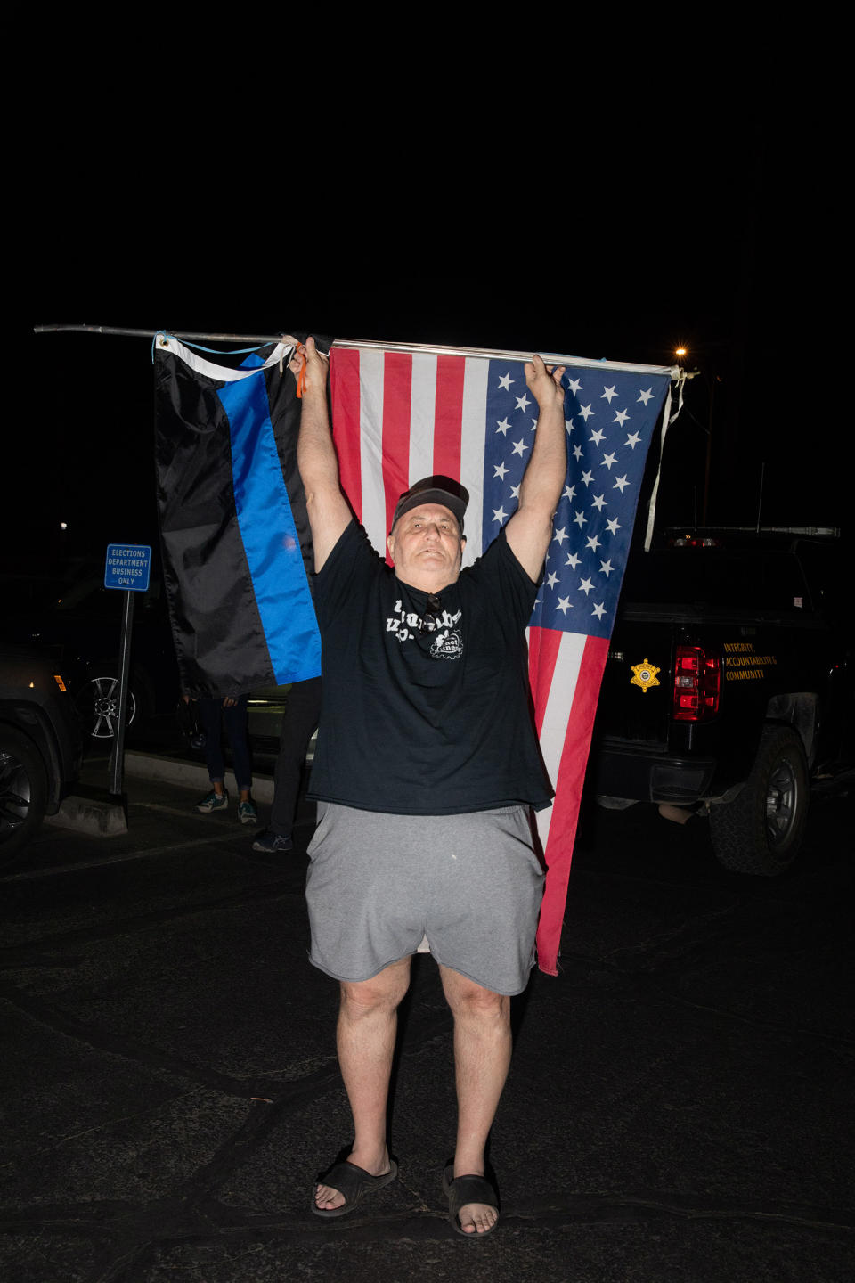 Trump supporter holds flags Maricopa County Elections Department office in Phoenix, on Nov. 4<span class="copyright">Sinna Nasseri for TIME</span>