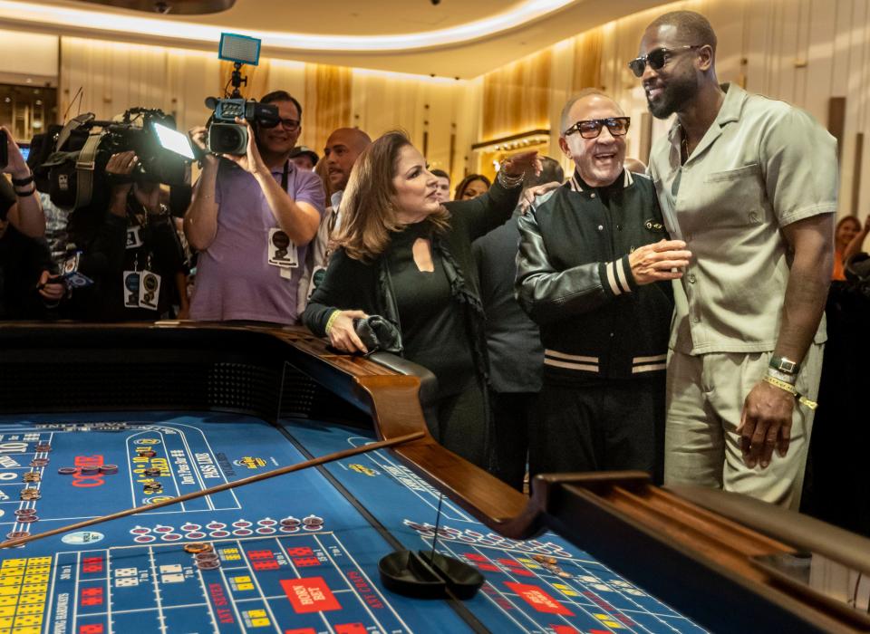 Gloria and Emilio Estefan greet former Miami Heat greet Dwayne Wade next to a craps table at the Seminole Hard Rock Hotel & Casino Hollywood.