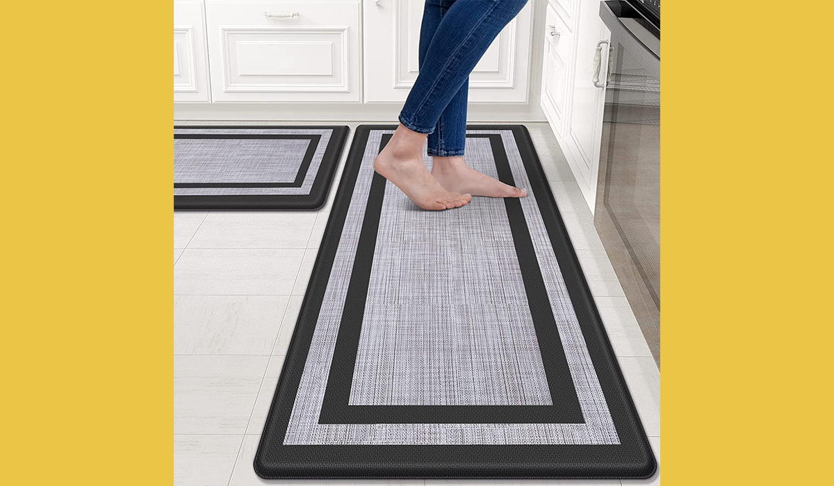 Barefoot woman standing on mat in kitchen