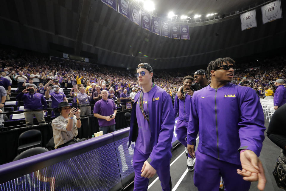 LSU quarterback Joe Burrow, lert, and wide receiver Ja'Marr Chase walk into the Pete Maravich Assembly center during a celebration for their NCAA college football championship, Saturday, Jan. 18, 2020, on the LSU campus in Baton Rouge, La. (AP Photo/Gerald Herbert)