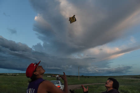 Mahto In The Woods throws a work glove in the air on the Cheyenne River Reservation in Green Grass, South Dakota, U.S., May 29, 2018. REUTERS/Stephanie Keith