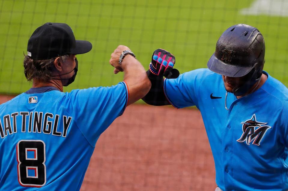 <p>Miguel Rojas #19 of the Miami Marlins reacts with manager Don Mattingly #8 after hitting a solo homer in the third inning against the Atlanta Braves during an exhibition game at Truist Park on July 21 in Atlanta.</p>
