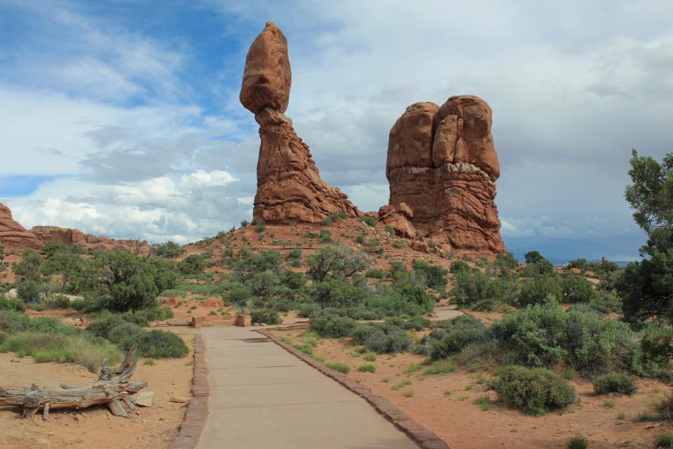 Hiking along with fins of sandstone rock in the nearly 8-mile long Devil's Garden Trail in Arches National Park, you'll come across a rare peculiarity in geology. One of the most iconic features is the teetering enormous sandstone boulder atop Balanced Rock, presumed to weigh about 3,677 tons.