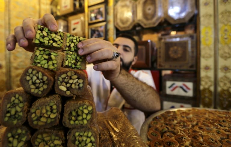 A worker arranges traditional Syrian delicacies at a shop in Damascus' Midan neighbourhood on September 11, 2017